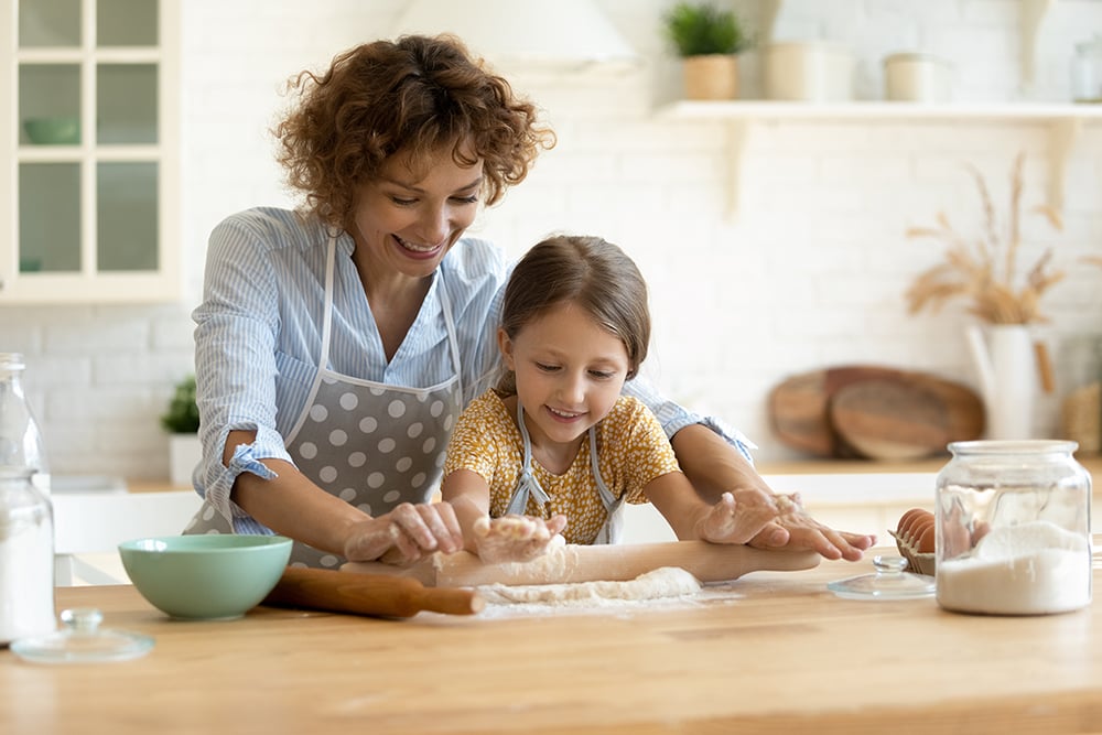 Mother and daughter baking with flour