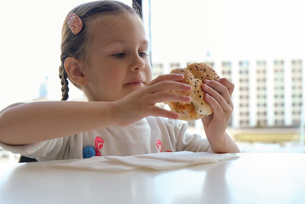 Little girl eating bun with sesame seeds Little girl eating bun with sesame seeds