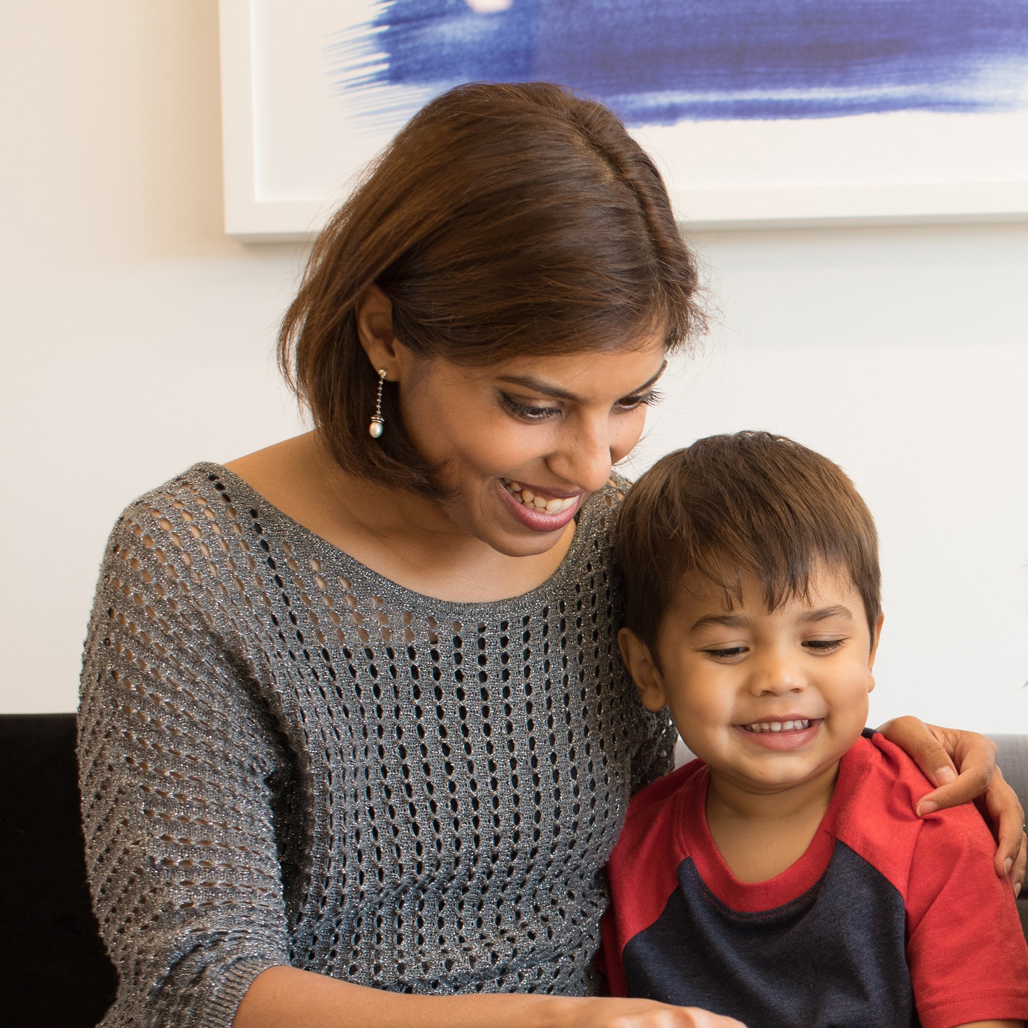 Mother and child share a smile while sitting in office